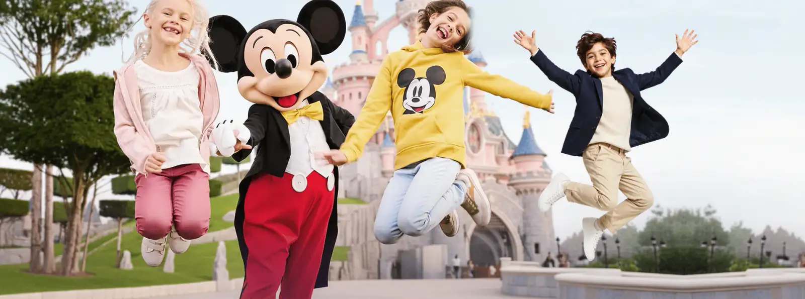 Happy family with Mickey Mouse in front of the Disneyland Paris castle